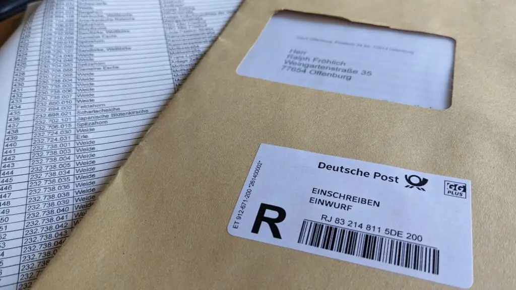Nahaufnahme eines braunen Umschlags mit einem Aufkleber der Deutschen Post und einer Adresse, die auf einem Dokument mit einer Reihe von Namen und Nummern liegt.