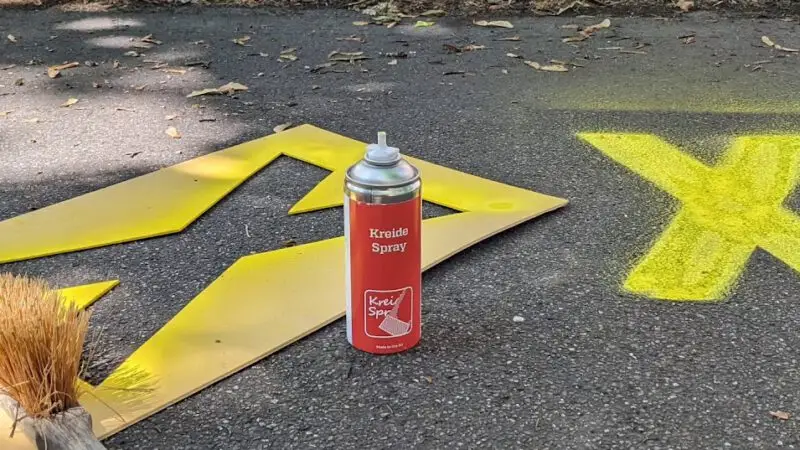 Gelbes Kreuz, Schablone und Kreidespray auf der Straße