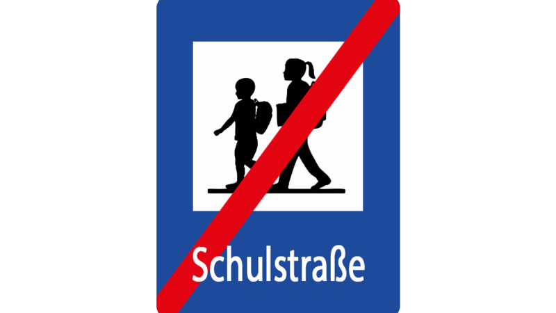 Ein blaues Schild mit den Silhouetten eines Jungen und eines Mädchens, die zu Fuß unterwegs sind, einer roten diagonalen Linie, die sie kreuzt, und dem Wort Schulstraße darunter, das das Ende einer Schulzone in Deutschland anzeigt.
