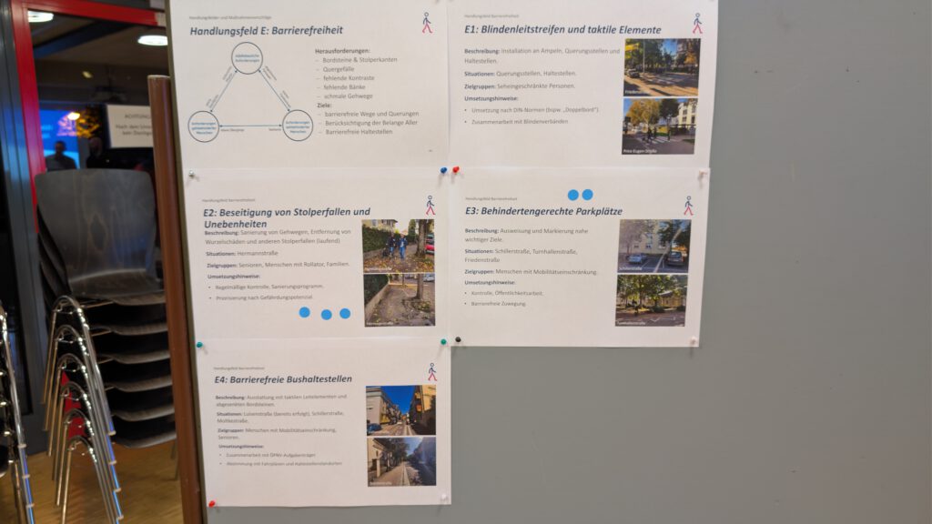 Eine Schautafel mit vier gedruckten Dokumenten über Barrierefreiheit in deutscher Sprache, jeweils mit Überschriften, Aufzählungspunkten und Fotos, die barrierefreie Straßen, Parkplätze, taktile Elemente und Bordsteinanpassungen illustrieren.