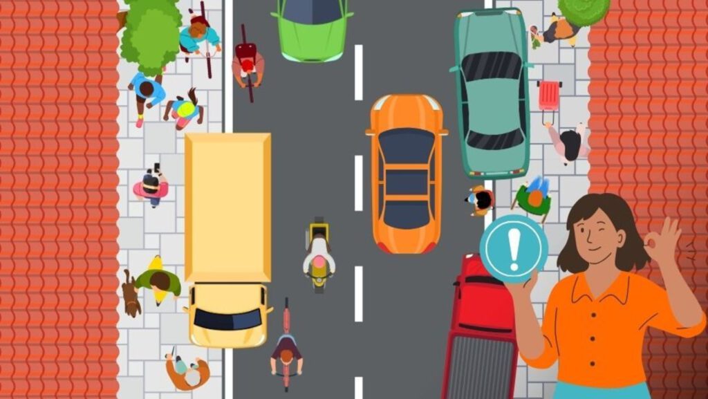 Eine Top-Down-Illustration einer belebten Straße mit Autos, einem Lastwagen und Menschen, die zu Fuß gehen oder Rollstühle auf Gehwegen benutzen. Eine Frau in einem orangefarbenen Hemd hält ein Ausrufezeichen-Symbol in der unteren rechten Ecke.