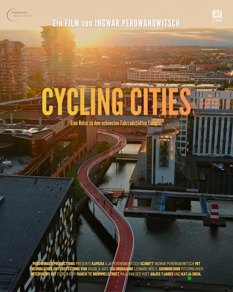 Luftaufnahme einer modernen Stadt mit einem roten, erhöhten Radweg, der sich über Wasser und zwischen Gebäuden hindurch schlängelt. Der Text CYCLING CITIES und der Filmabspann sind auf Deutsch eingeblendet.