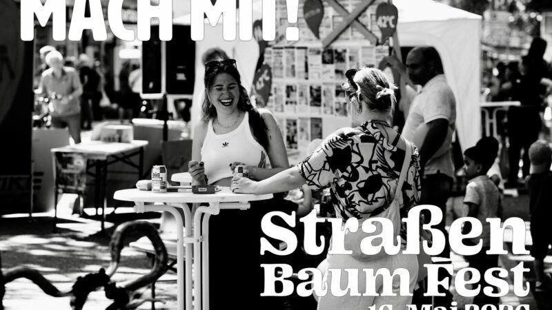 Schwarz-Weiß-Foto von lächelnden und sich unterhaltenden Menschen bei einer Veranstaltung im Freien mit Informationsständen. Der große Text lautet: Mach mit! Straßen Baum Fest 16. Mai 2026. Bildnachweis: Uwe Nestlen.