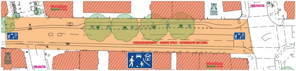 Eine Karte, die eine gemeinsam genutzte Straße mit markierten Fußgänger-, Fahrrad- und Fahrzeugzonen, grünen Baumflächen und gekennzeichneten umliegenden Gebäuden zeigt. Blaue Schilder kennzeichnen Fußgänger- und Gemeinschaftsbereiche.