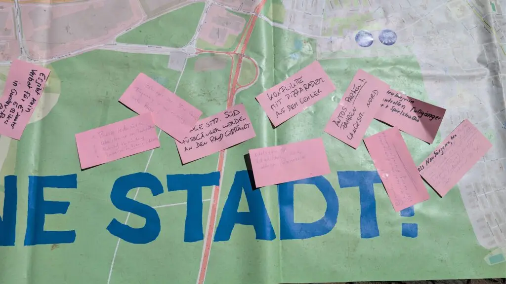 Map spread with pink sticky notes bearing handwritten messages on a city plan background.